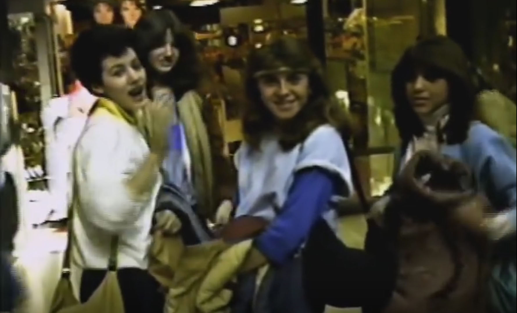 screenshot from the 1983 video documentary "Mall City." Pictured is a group of four teen girls at a Long Island mall being interviewed by the filmmaker.