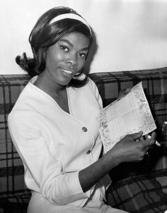 American singer Dionne Warwick reading a well-wishing telegram from Dusty Springfield at her London hotel, 20th May 1964