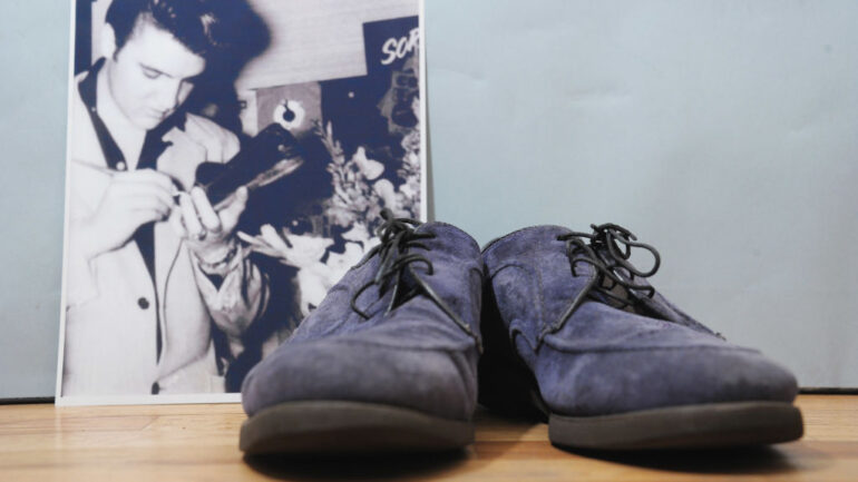 An autographed pair of Elvis Presley's original blue suede shoes and a photo of him autographing them on auction at Gotta Have It! store on March 21, 2012 in New York City