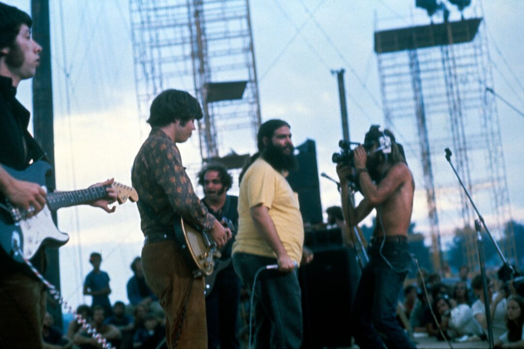 WOODSTOCK, 'Canned Heat' getting ready to play, Bob 'Bear' Hite (lead singer, center, in yellow T-Shirt), 1970. 