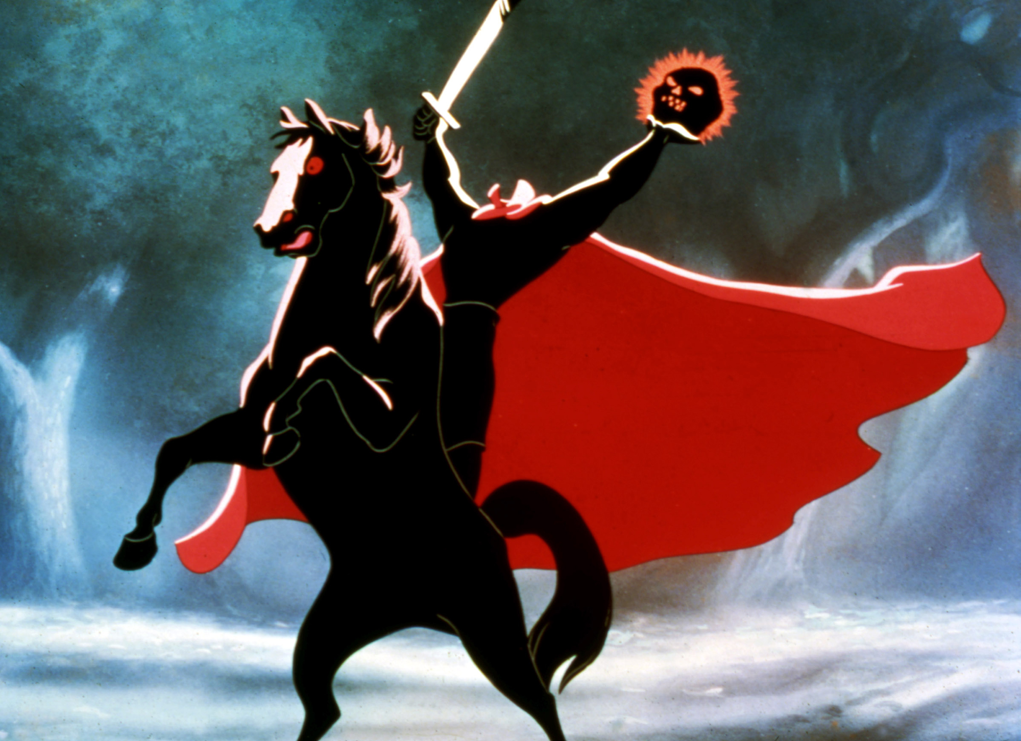 image from the "Legend of Sleepy Hollow" segment from Disney's 1949 animated package film "The Adventures of Ichabod and Mr. Toad." It depicts the Headless Horseman, astride his rearing horse. The Horseman is dressed in black with a long, red cape flowing behind him. In his right hand he holds a sword; in his left, a flaming pumpkin. His steed is all black except for fiery red eyes.