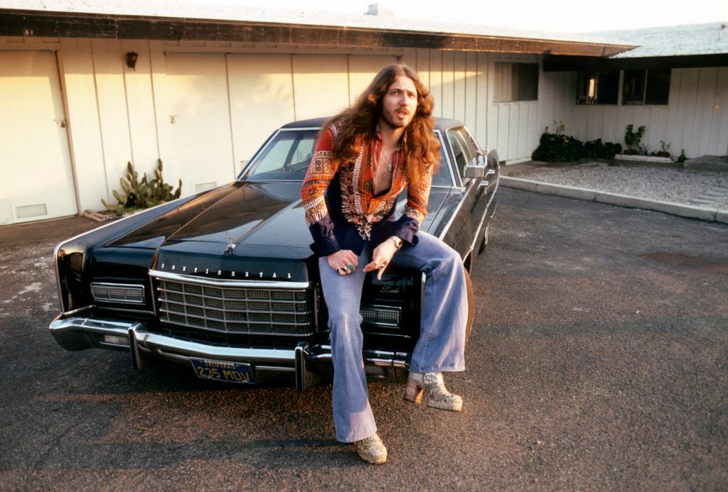 Photo of David COVERDALE and DEEP PURPLE; David Coverdale, posed, sitting on bonnet of car