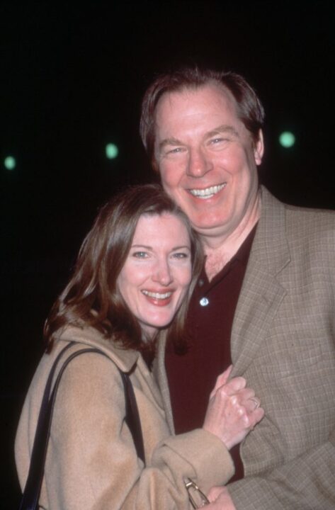 January 2000: Married American actors Michael McKean and Annette O'Toole smile while embracing at the premiere of director Eric Schaeffer's film 'Wirey Spandell,' Los Angeles, California. O'Toole wears a camel hair coat while McKean wears a khaki sportsjacket and burgundy polo shirt