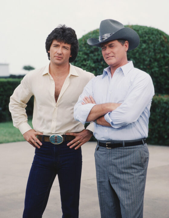 American actors Patrick Duffy (left) and Larry Hagman, as Bobby Ewing and John Ross 'J.R.' Ewing Jr., stand together in a promotional still from the American television series 'Dallas,' August 1982.